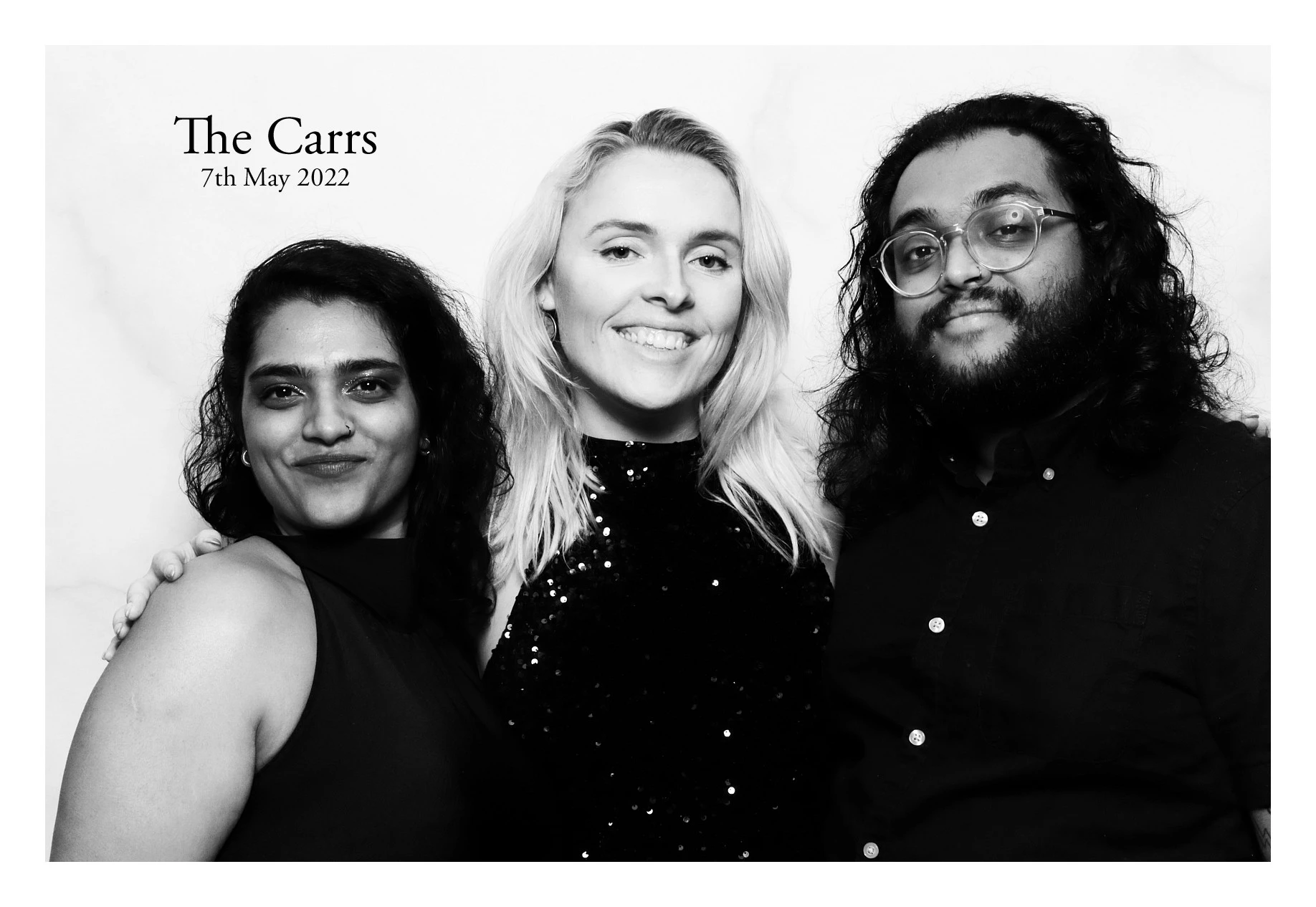 Three friends posing for a formal black and white photo, titled 'The Carrs, 7th May 2022'.